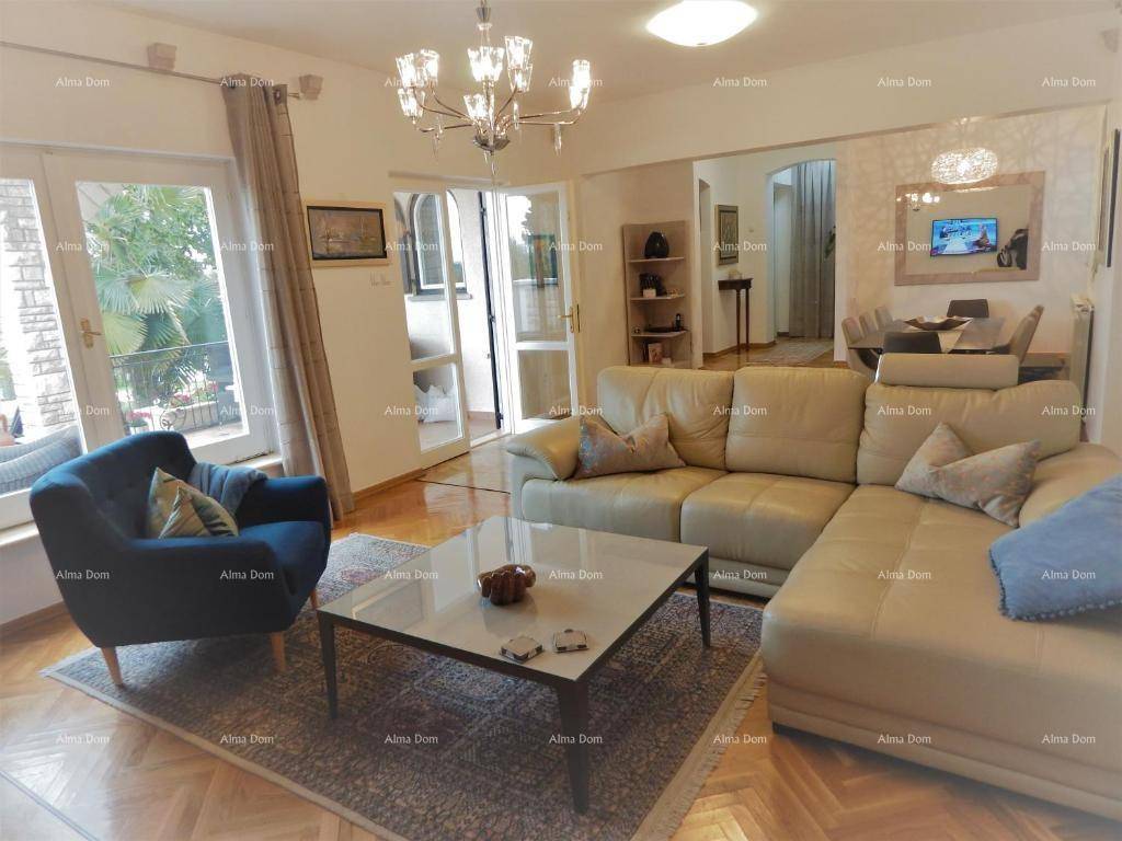Lichtdurchflutetes Wohnzimmer mit beigem Sofa, Parkettboden und Zugang zum Balkon.