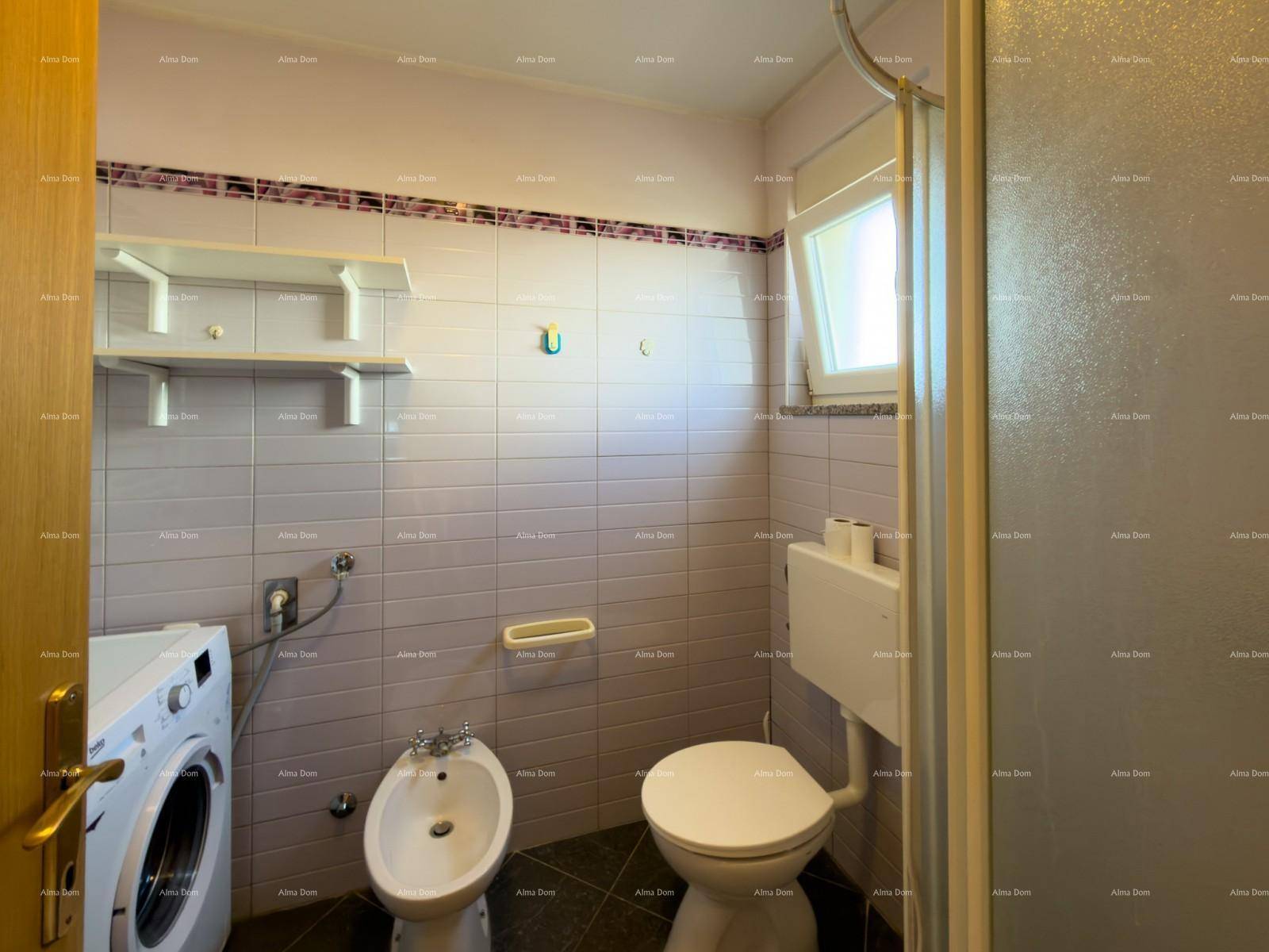 Badezimmer mit Duschkabine, Bidet, WC und Waschmaschine, gefliest in Lila.