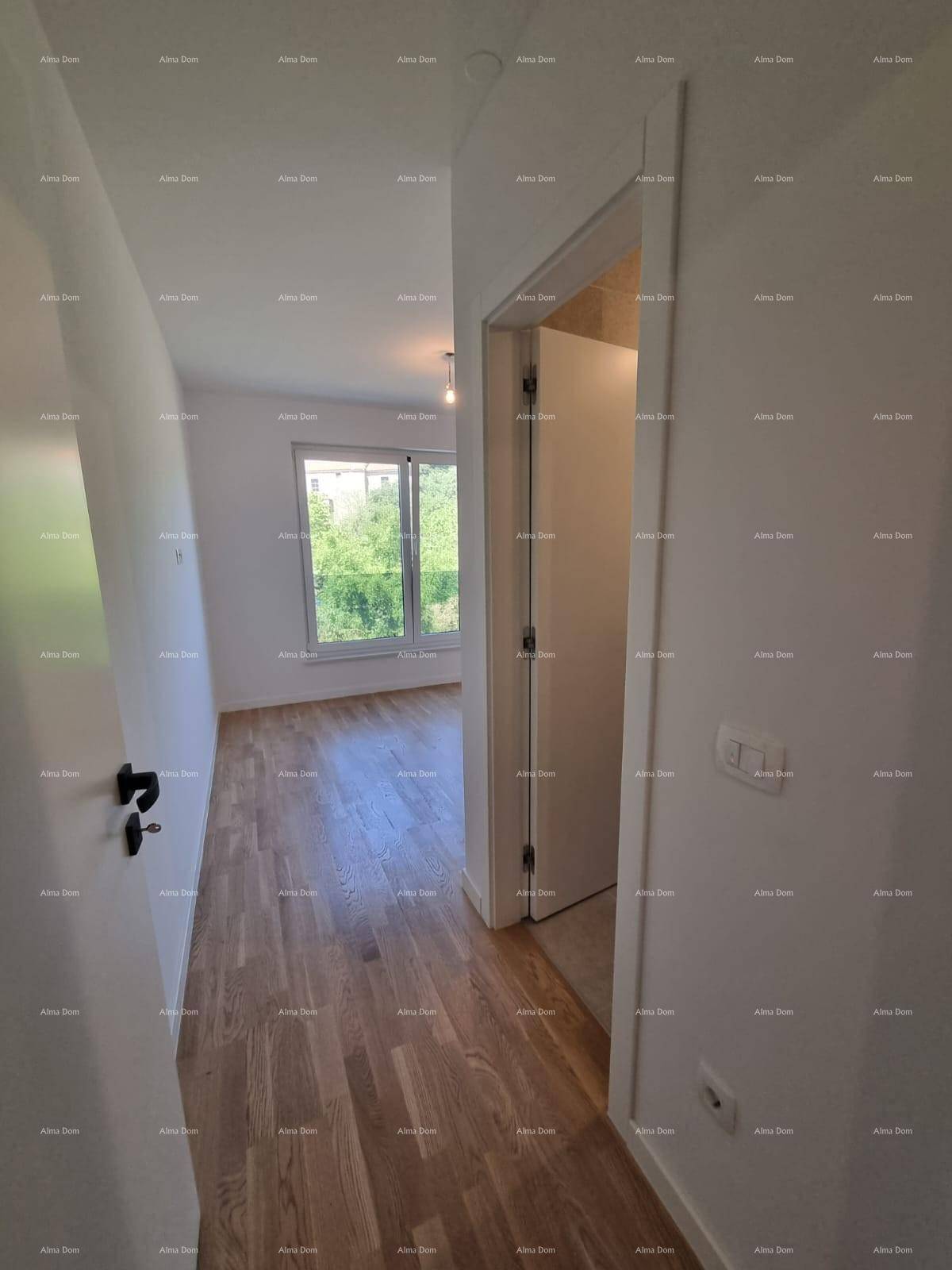 Heller Flur mit Holzparkett, der zu einem Zimmer mit Blick ins Grüne führt.