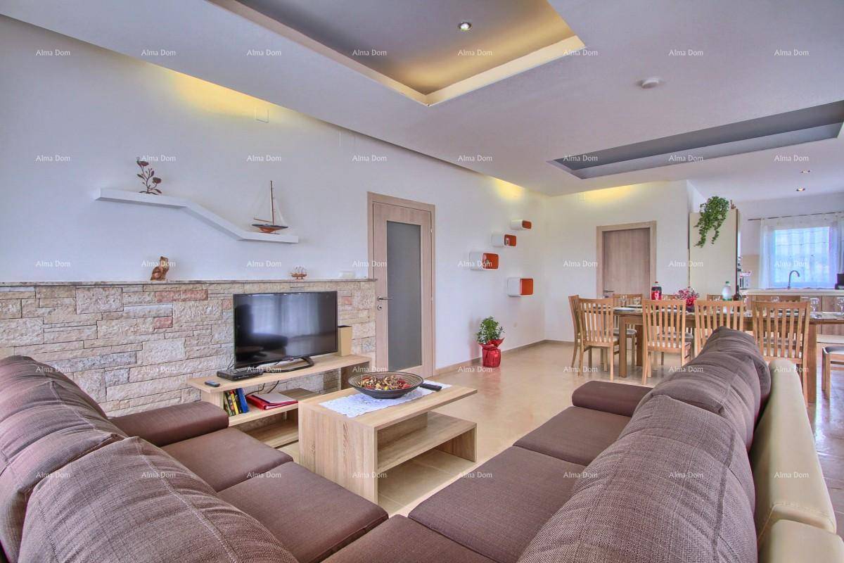 Gemütlicher Wohnbereich mit Sofa und Blick auf den Ess- und Küchenbereich.