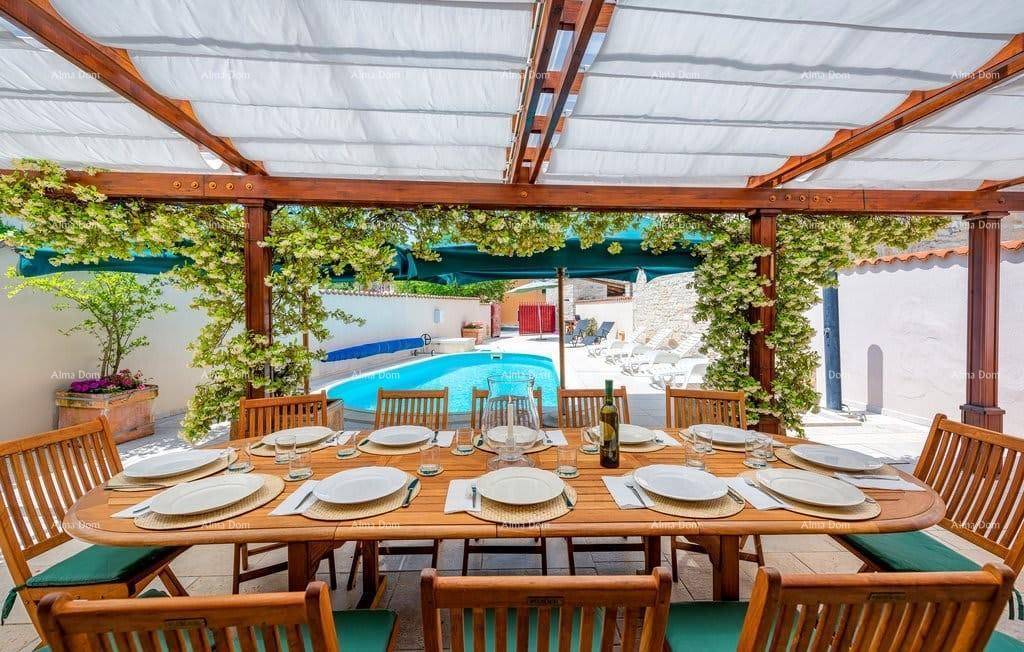 Festlich gedeckter Esstisch auf der überdachten Terrasse mit Blick auf den privaten Pool.