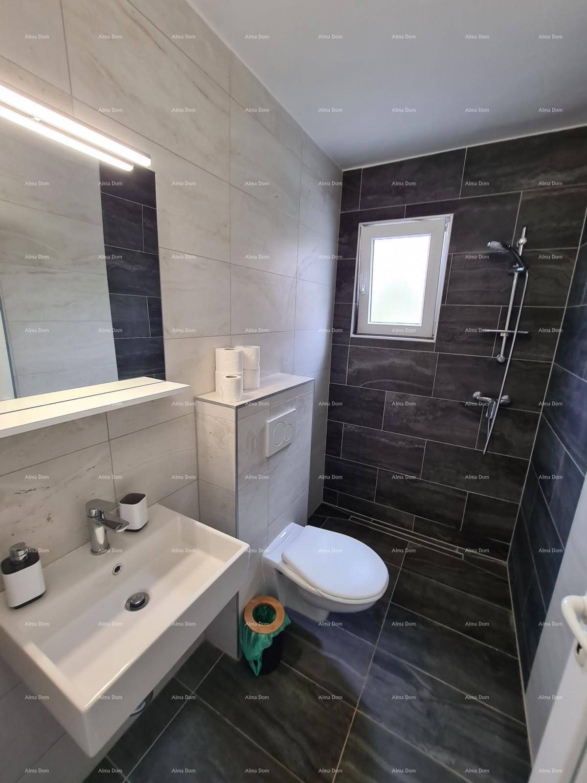 Modernes Badezimmer mit Fenster, dunklen Fliesen, Dusche und wandhängendem WC.