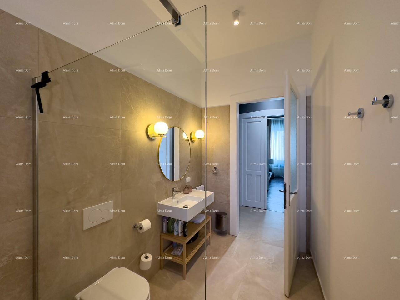 Helles Badezimmer mit modernen Armaturen, großformatigen Fliesen und Zugang zu einem weiteren Raum.