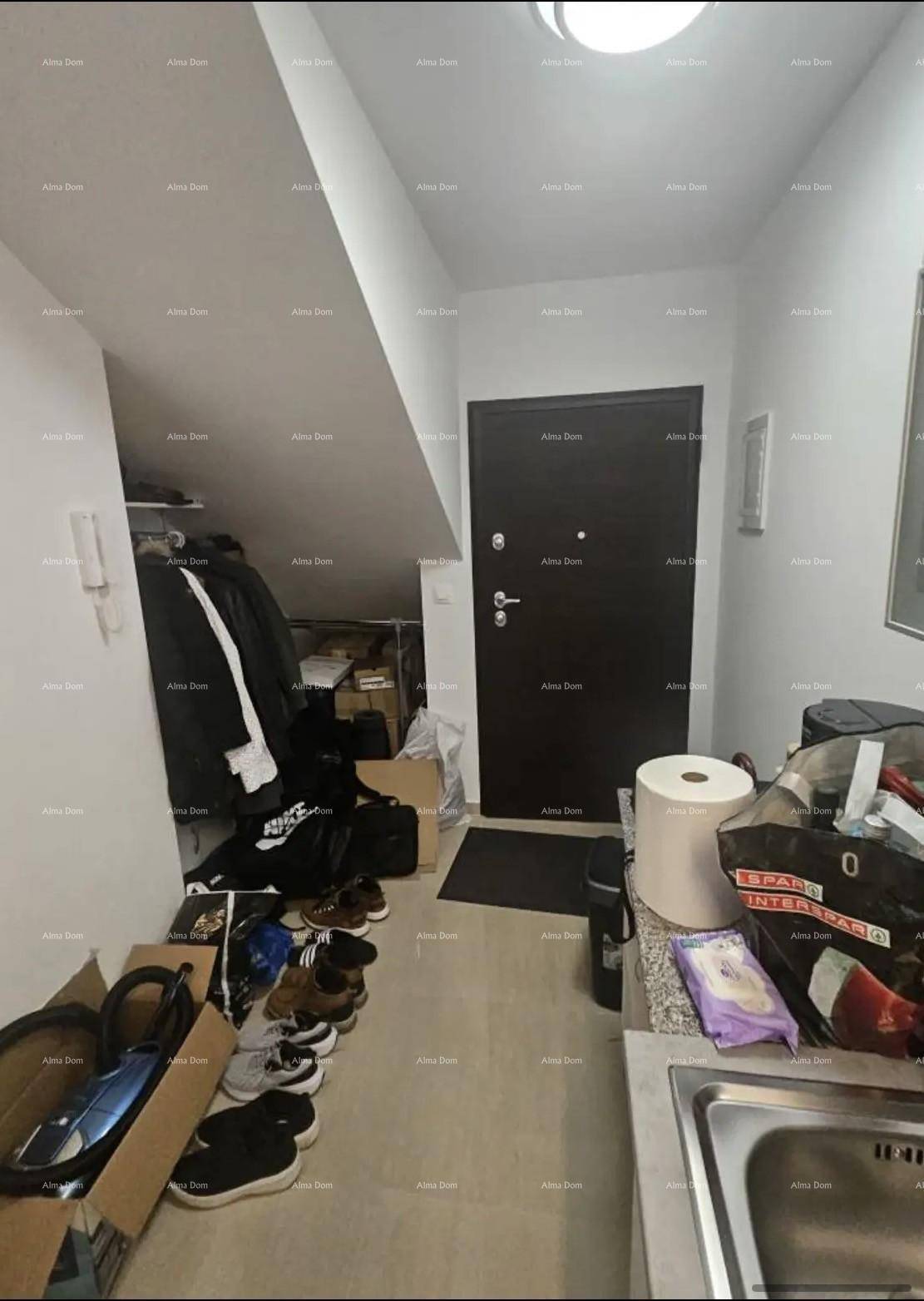 Eingangsbereich mit Dachschräge, Stauraum und kleiner Spüle, ideal für eine Dachgeschosswohnung.