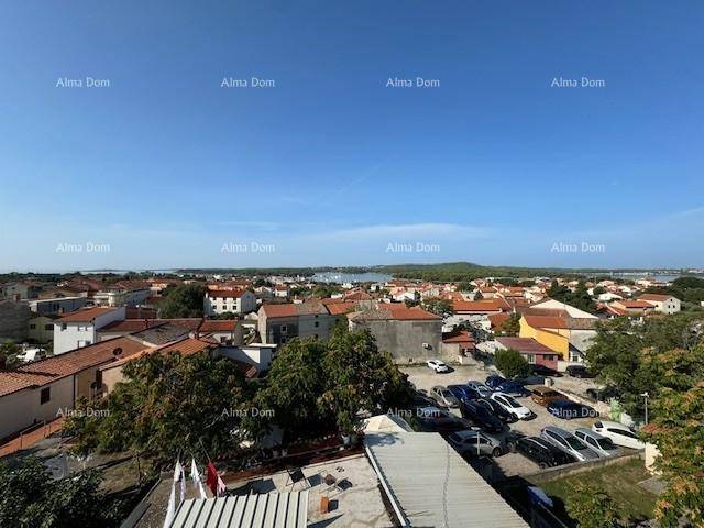 Weitläufiger Blick über die Stadt und die Küste unter einem klaren blauen Himmel.