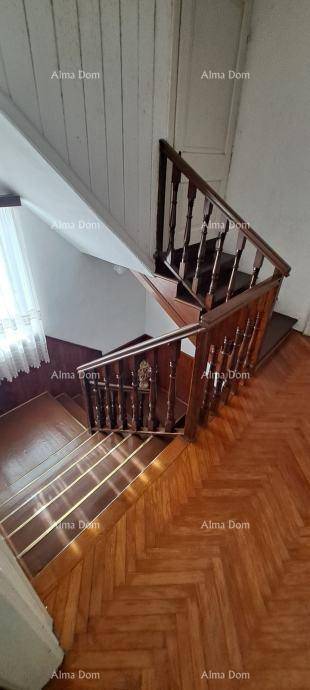 Geschwungene Holztreppe mit Fischgrätparkett und viel natürlichem Licht.
