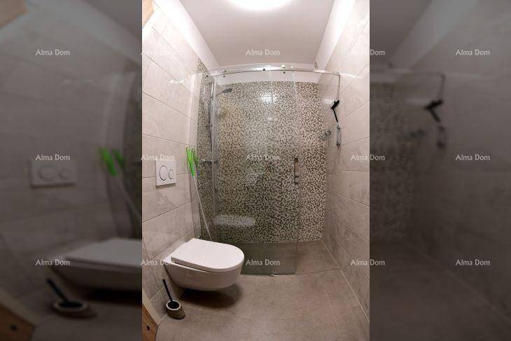 Modernes Badezimmer mit Duschkabine, wandhängendem WC und hellen Fliesen.