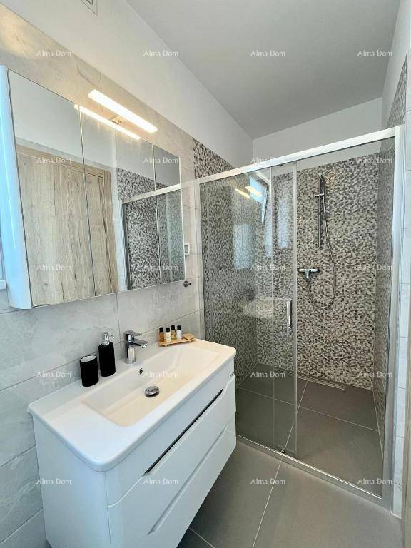 Modernes Badezimmer mit Duschkabine, Waschbecken und Spiegelschrank.