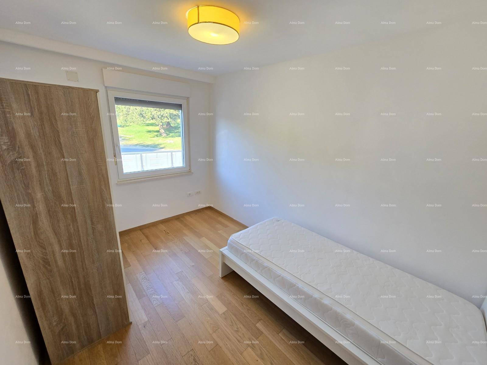 Helles Schlafzimmer mit Einzelbett, Holzboden und Fenster mit Blick ins Grüne.