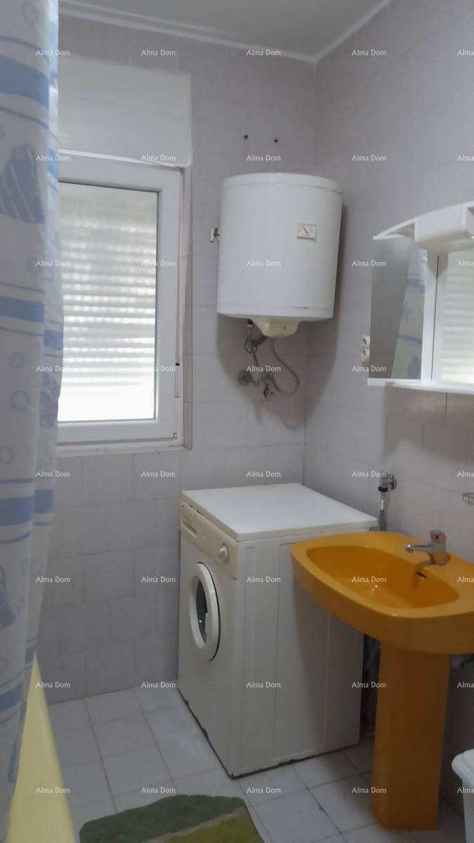 Badezimmer mit Waschmaschine, gelbem Waschbecken und Boiler, ausgestattet mit einem Fenster.