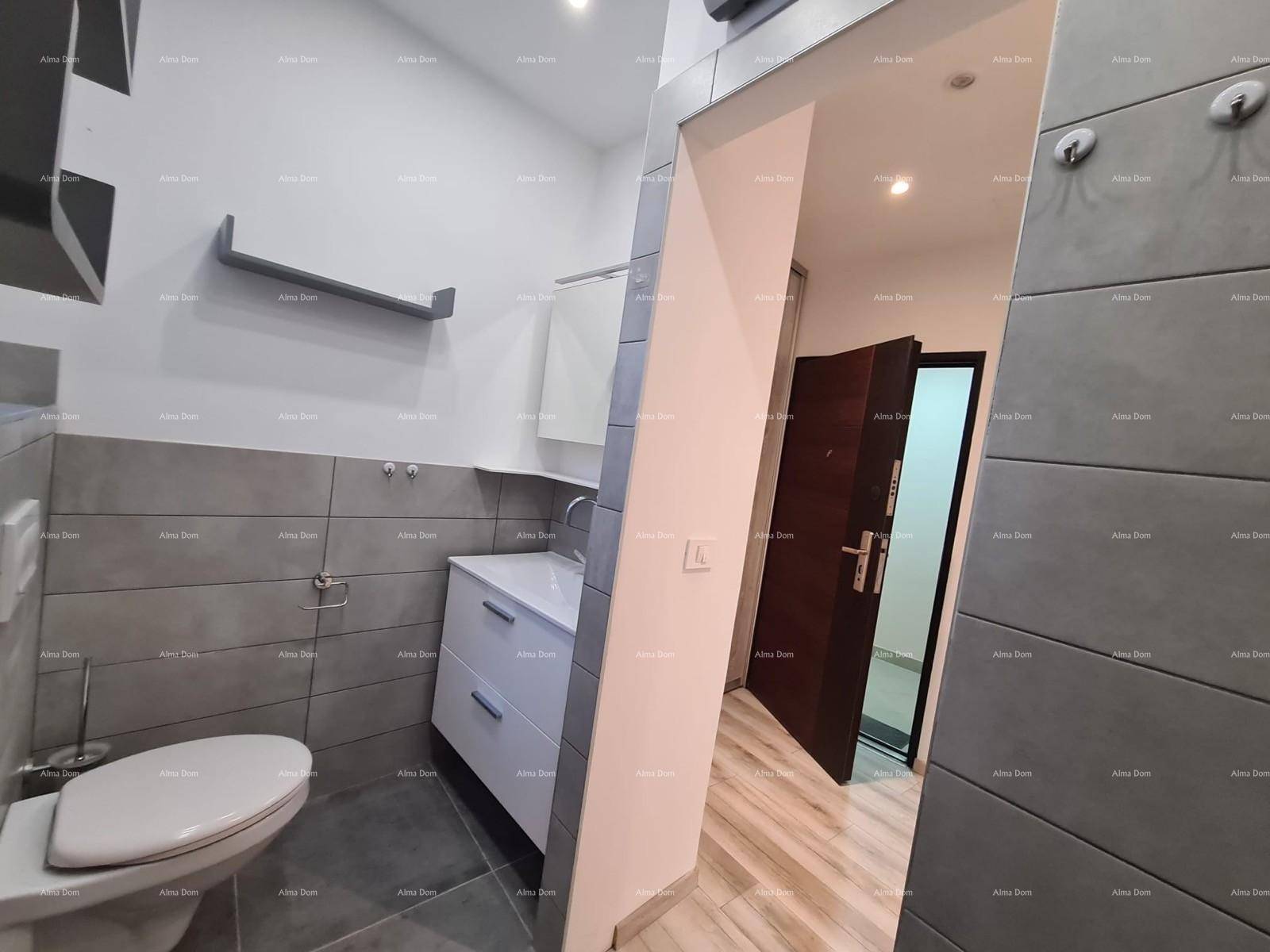Modernes Badezimmer mit grauen Fliesen, wandhängendem WC und Waschtischunterschrank.