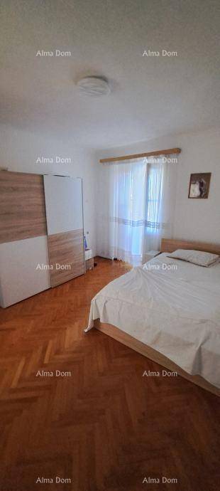 Helles Schlafzimmer mit Doppelbett, Holzparkett und einem modernen Kleiderschrank.