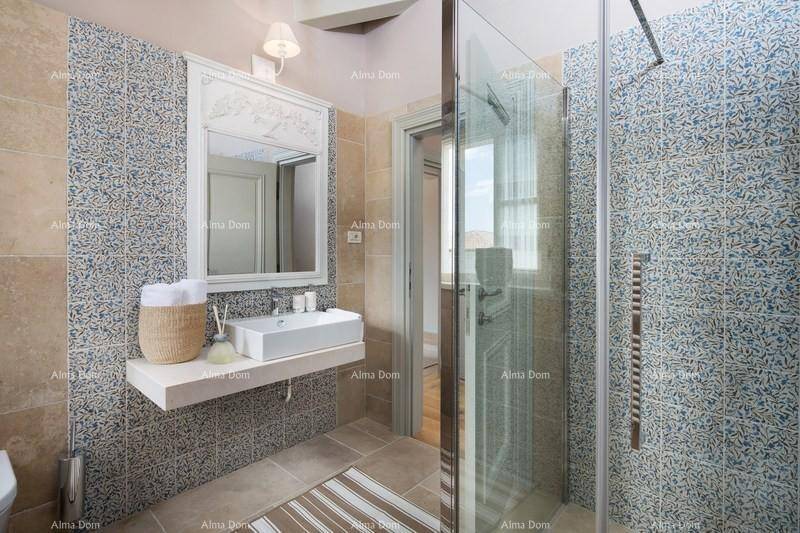 Stilvolles Badezimmer mit gemusterten Fliesen, modernem Waschbecken und großer Dusche.
