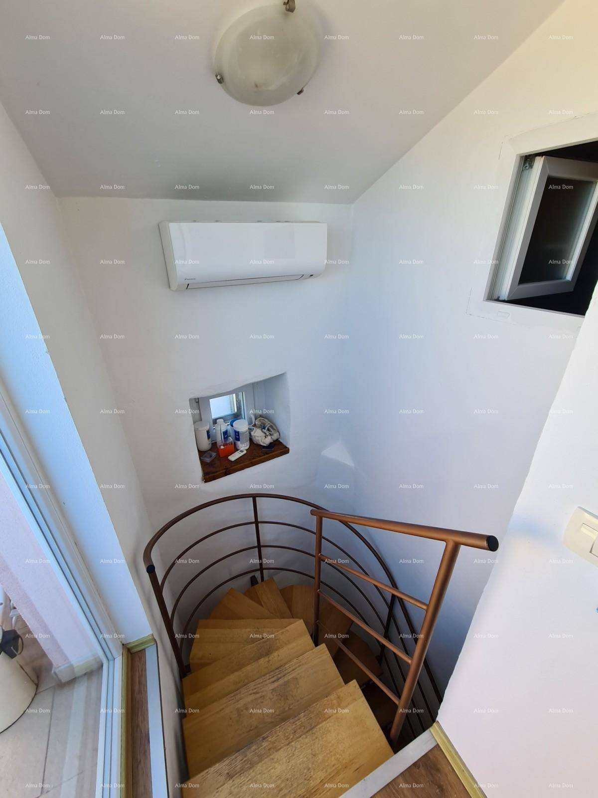 Wendeltreppe aus Holz mit Metallgeländer, die zu den oberen Etagen führt.