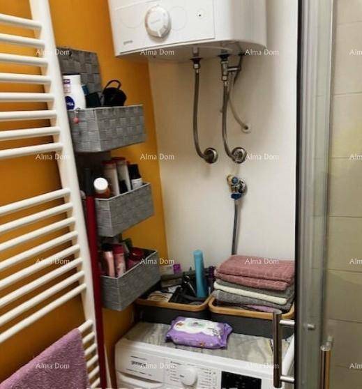 Badezimmer mit Waschmaschine, Handtuchheizkörper und Boiler, praktisch eingerichtet.