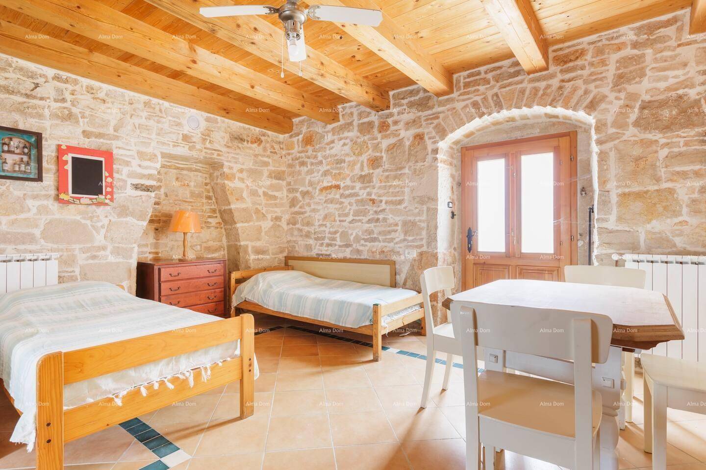 Schlafzimmer mit Holzbalkendecke, Steinwänden und zwei Einzelbetten.