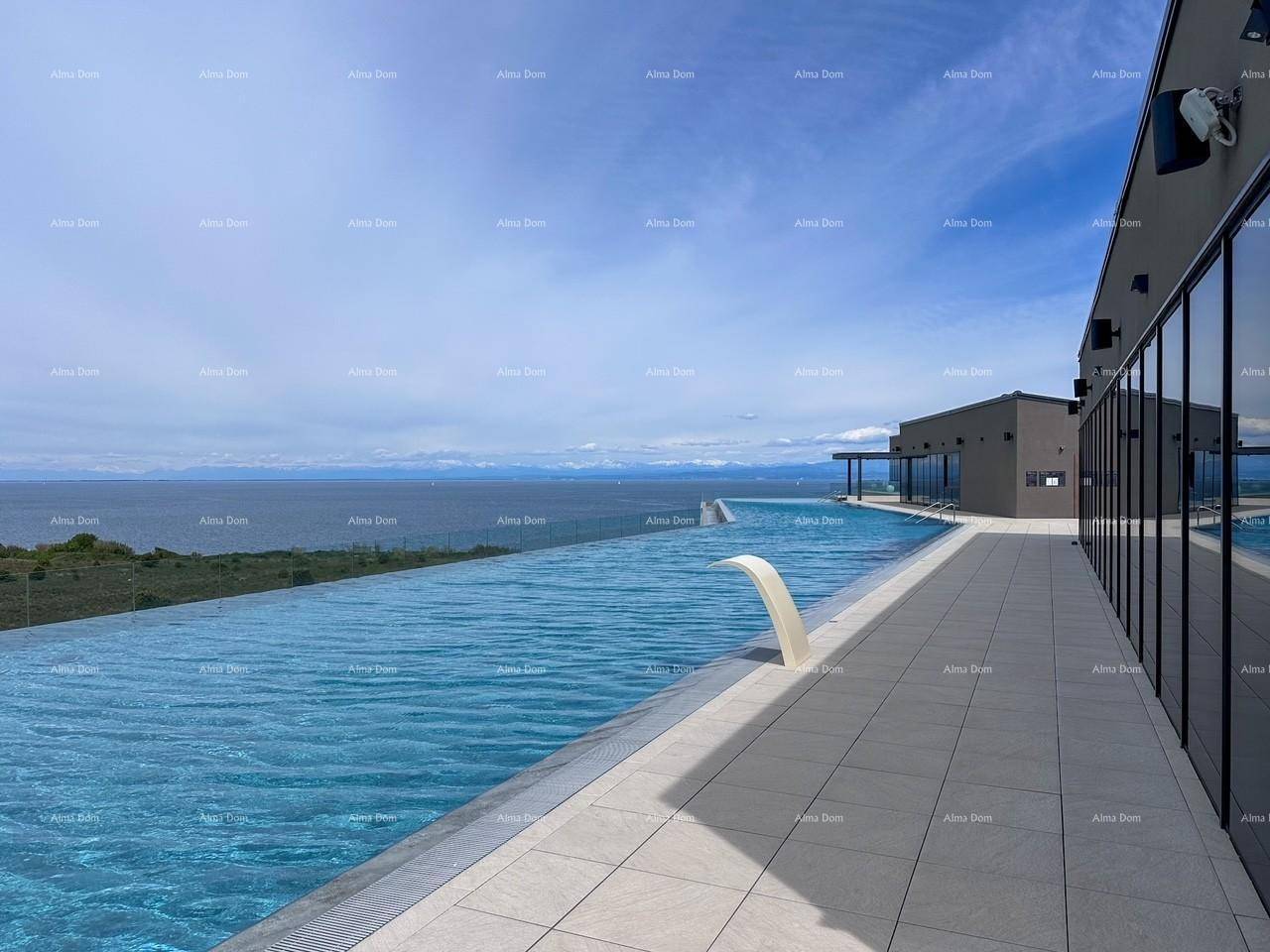 Infinity-Pool mit elegantem Wasserspiel neben einem modernen Gebäude, mit Panoramablick auf das Meer.