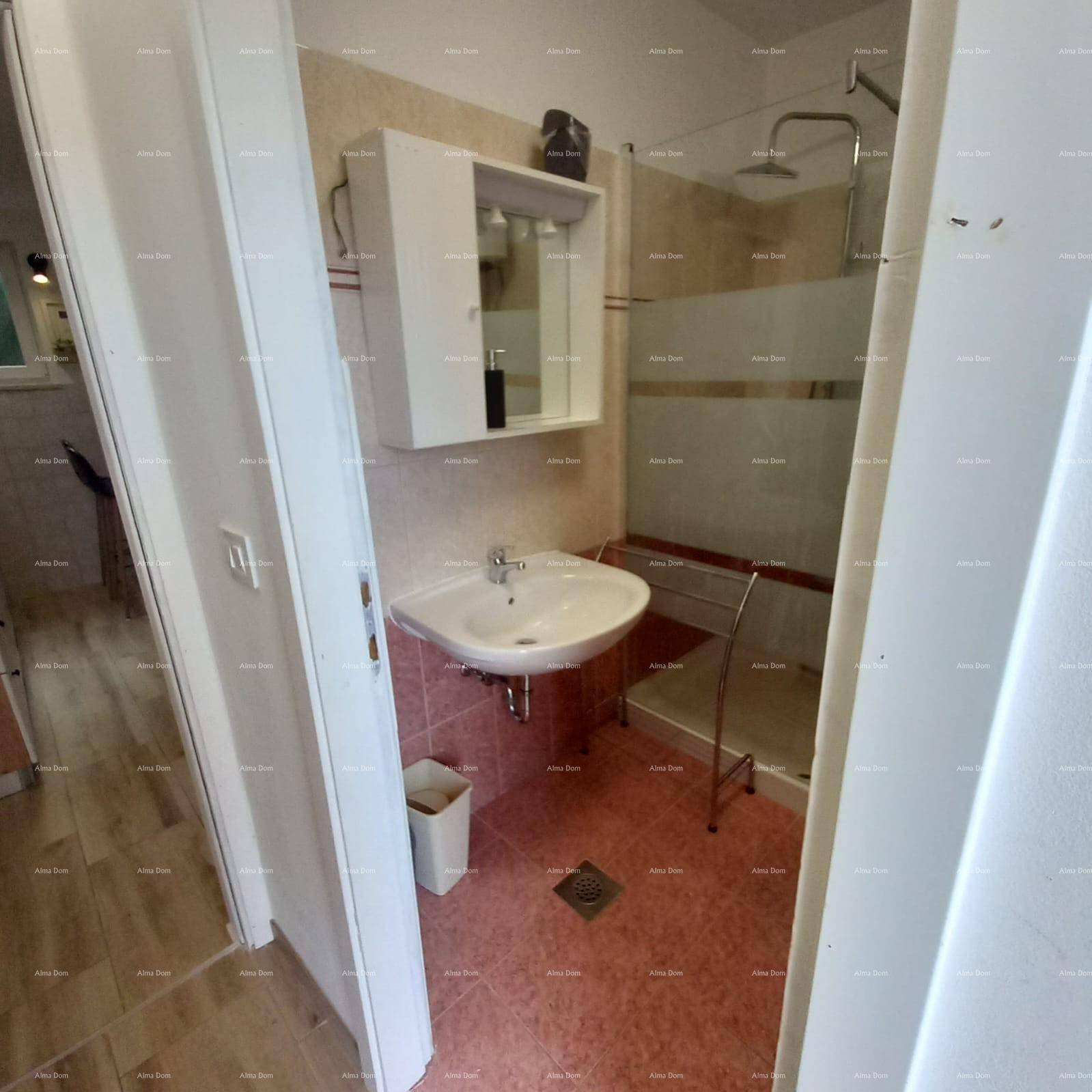 Modernes Badezimmer mit Dusche, Waschbecken und Fliesen in Rosa- und Beigetönen.