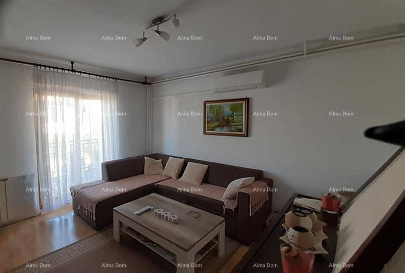 Gemütliches Wohnzimmer mit großem Ecksofa, Couchtisch und Zugang zum Balkon, ausgestattet mit Klimaanlage.