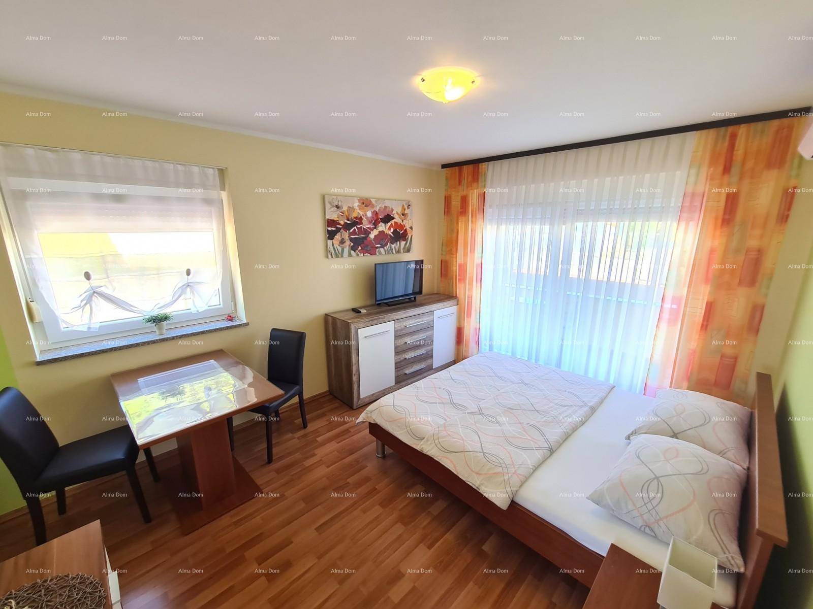 Helles Schlafzimmer mit Doppelbett, kleinem Esstisch und Fernseher, freundlich gestaltet.