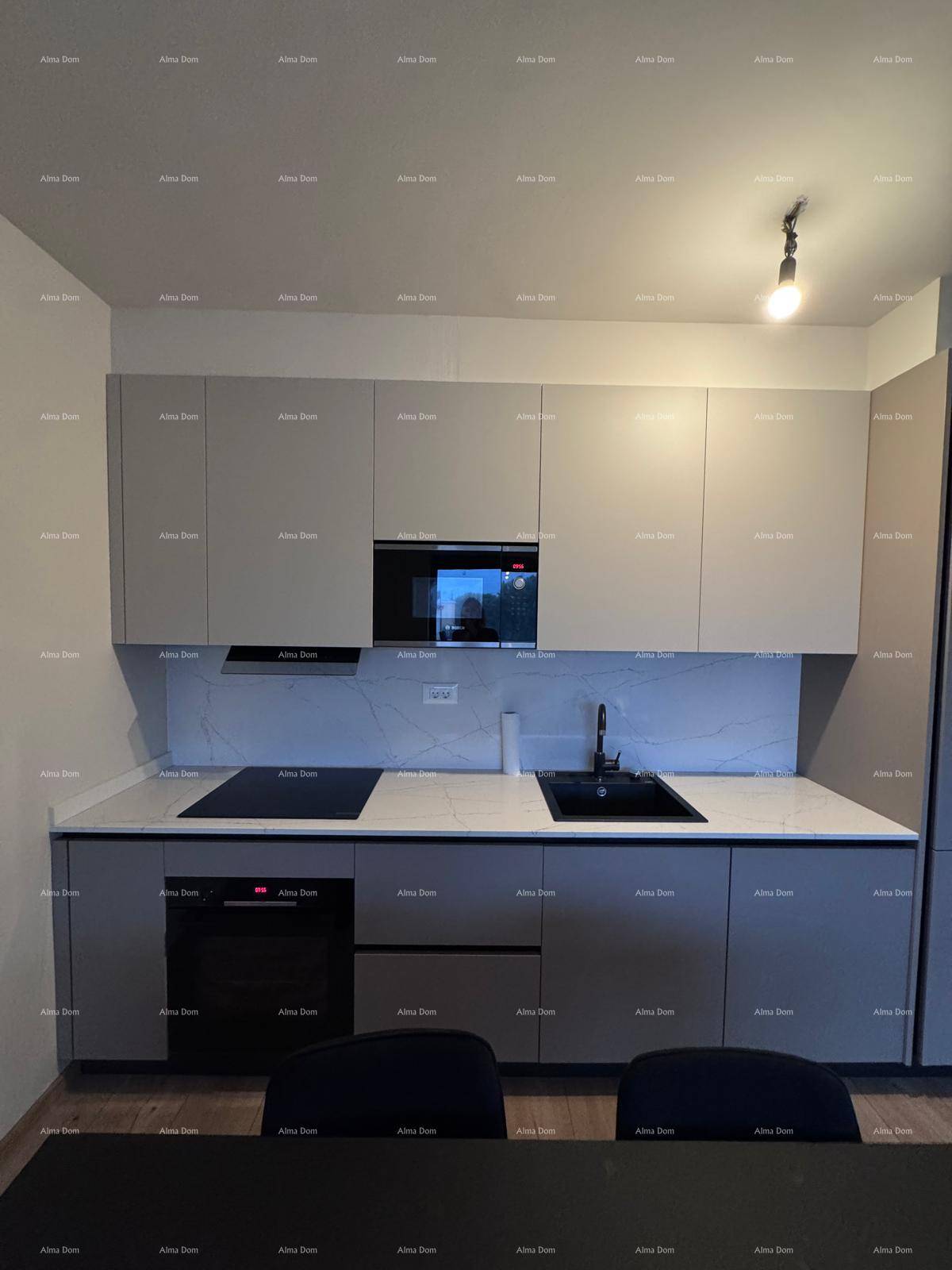 Moderne Einbauküche mit grauen Schränken, Induktionskochfeld und integriertem Backofen.