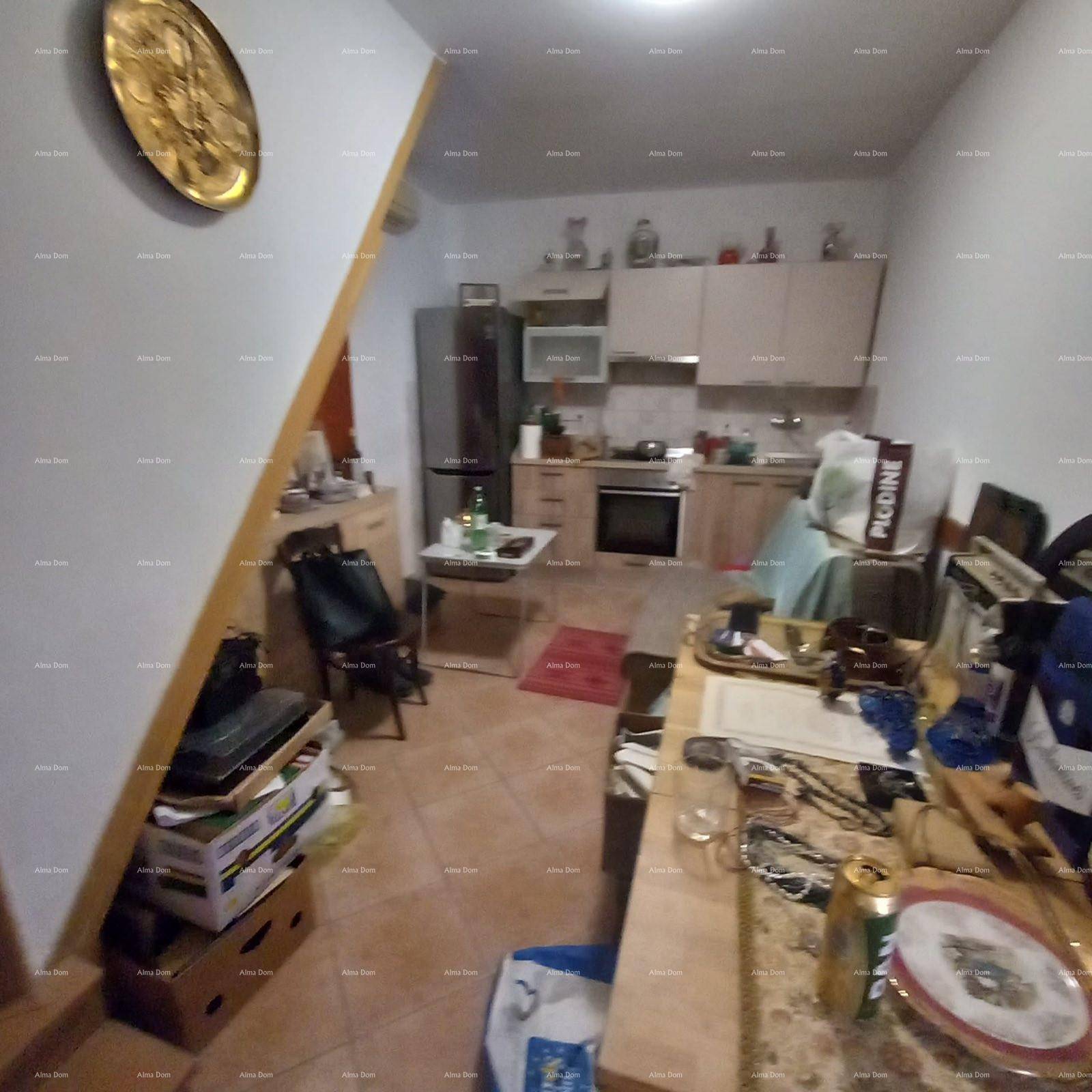 Kleine Küche mit Einbauschränken, Kühlschrank und einem Esstisch.