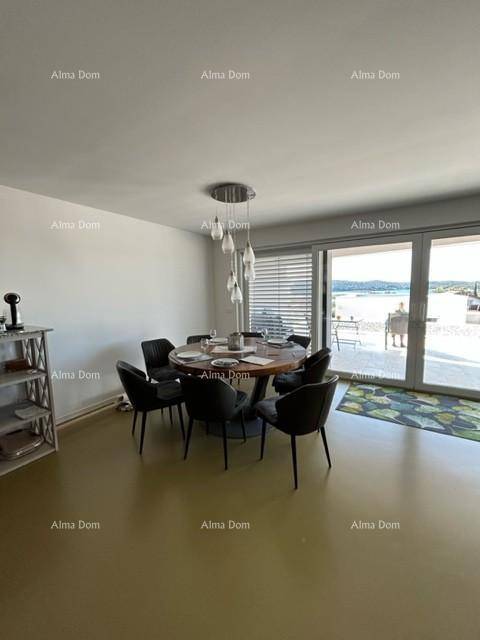 Eleganter Essbereich mit rundem Tisch und Stühlen, mit Blick auf die Außenterrasse.
