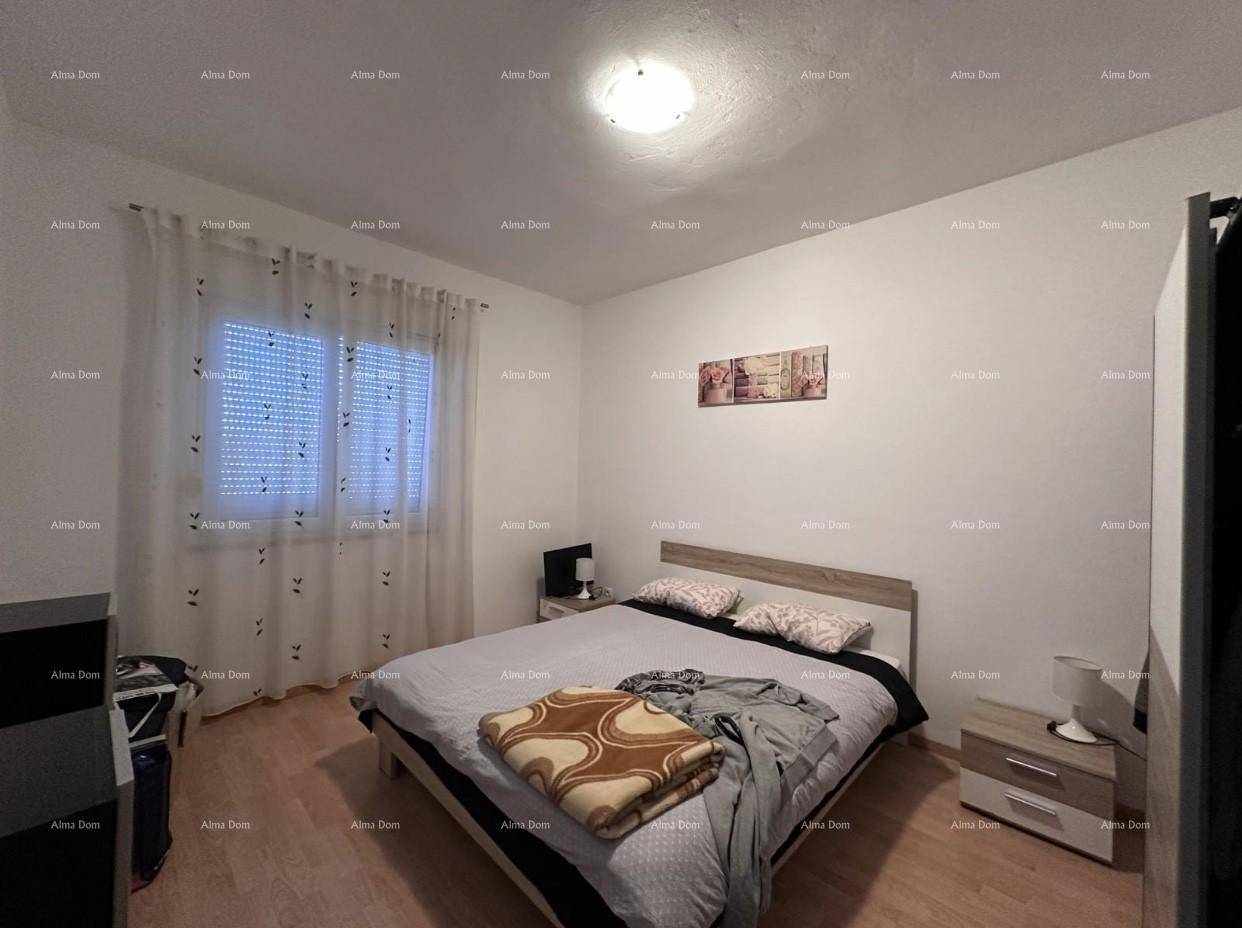 Komfortables Schlafzimmer mit Doppelbett, Nachttischen und Vorhängen am Fenster.