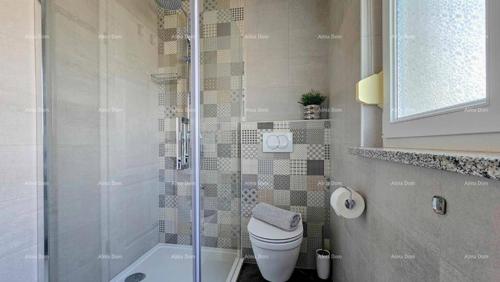 Modernes Badezimmer mit Duschkabine, Wand-WC und gemusterten Fliesen.