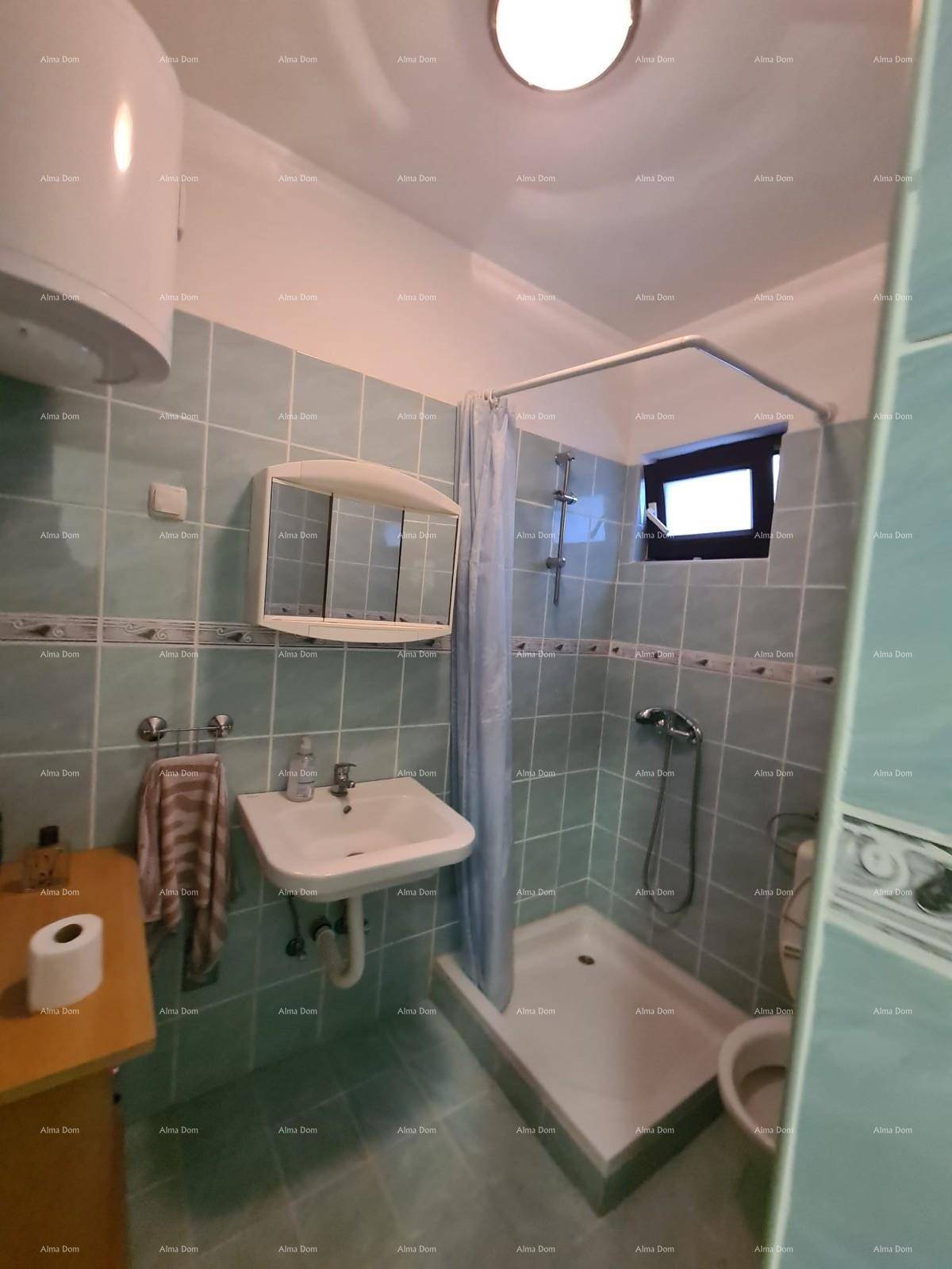 Badezimmer mit Dusche, Waschbecken und Toilette, ausgestattet mit hellblauen Fliesen.