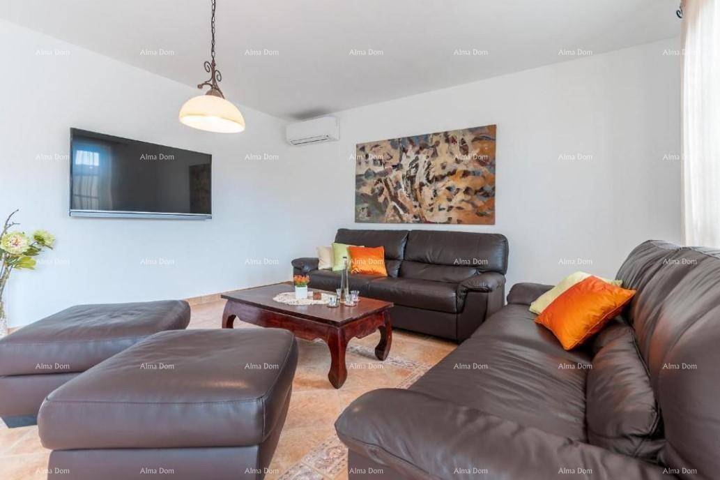 Gemütliches Wohnzimmer mit Ledersofas, Flachbildfernseher und Klimaanlage an der Wand.