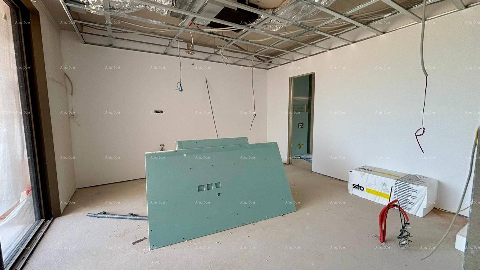 Raum im Rohbau mit vorbereiteten Wänden, sichtbarer Deckenkonstruktion und Baumaterialien.