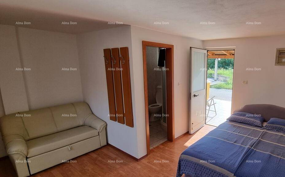 Schlafzimmer mit Doppelbett, Sofa und Zugang zum Außenbereich, ideal für Entspannung.