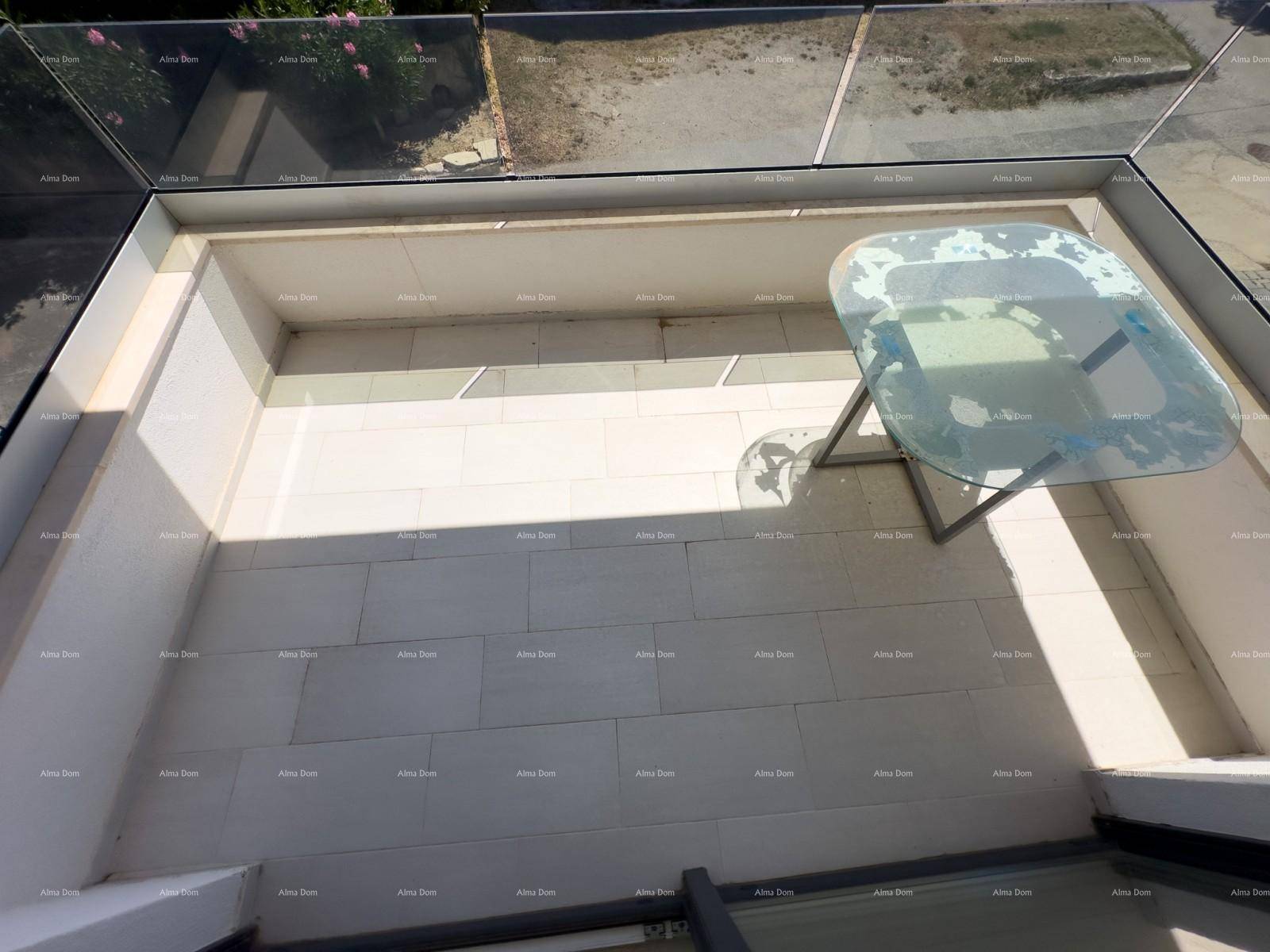Kleiner, überdachter Außenbereich mit einem Glastisch und Blick auf die Umgebung.