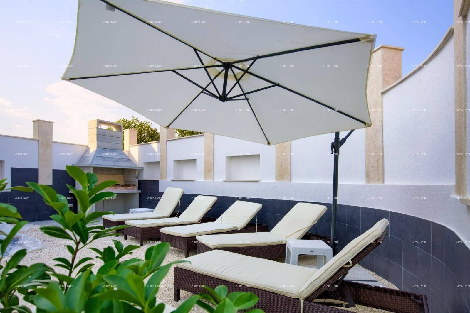 Gemütlicher Außenbereich mit Sonnenliegen, großem Sonnenschirm und integriertem Grillplatz für entspannte Stunden.