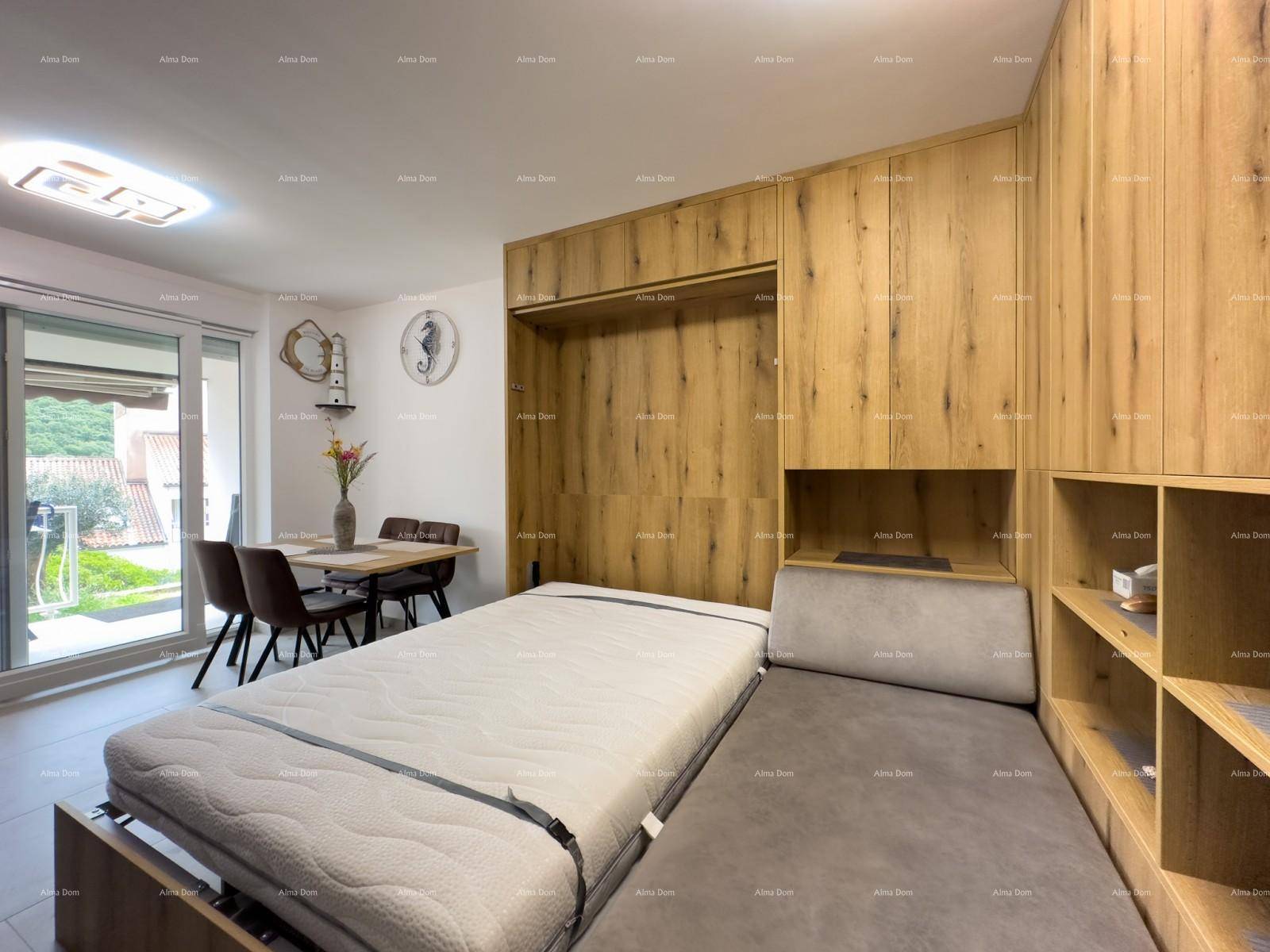 Wohn- und Essbereich mit ausziehbarem Bett, Holzelementen und Zugang zum Balkon.