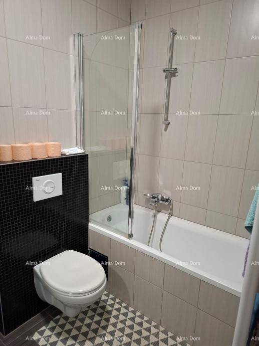 Badezimmer mit Badewanne inklusive Duschwand und einem modernen Wand-WC.