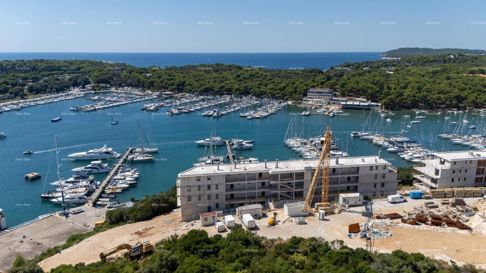 Luftaufnahme einer Baustelle am Yachthafen mit Blick auf das offene Meer in der Ferne.