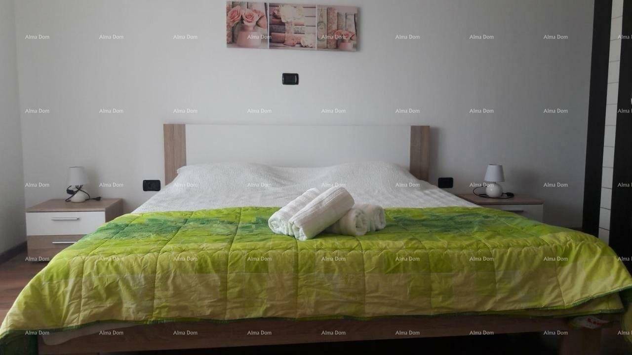 Schlafzimmer mit Doppelbett, Nachttischen und einem grünen Bettüberwurf.