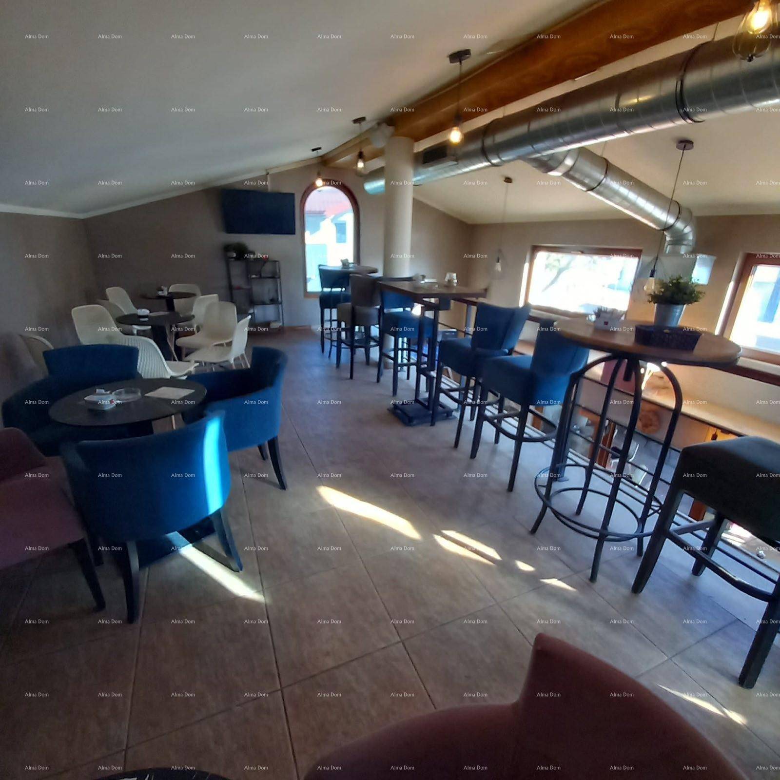 Obergeschoss einer Bar mit verschiedenen Sitzbereichen, Fliesenboden und sichtbaren Lüftungsrohren.