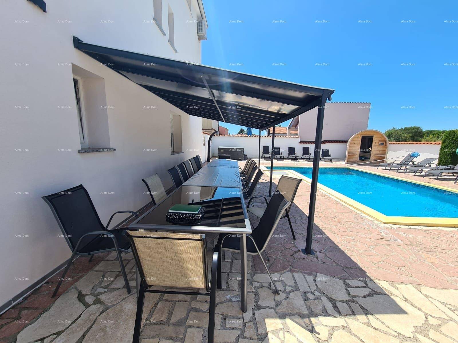 Überdachte Terrasse mit langem Esstisch und Blick auf den Poolbereich.