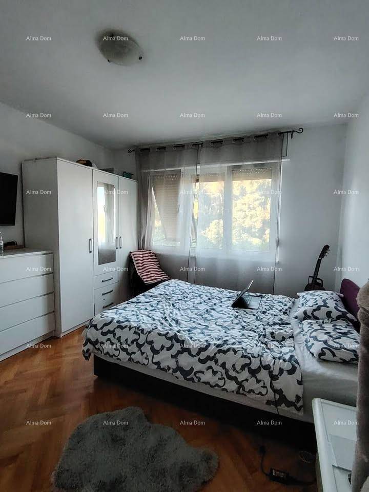 Gemütliches Schlafzimmer mit Doppelbett, weißem Kleiderschrank und Fenster, ausgestattet mit Parkettboden.