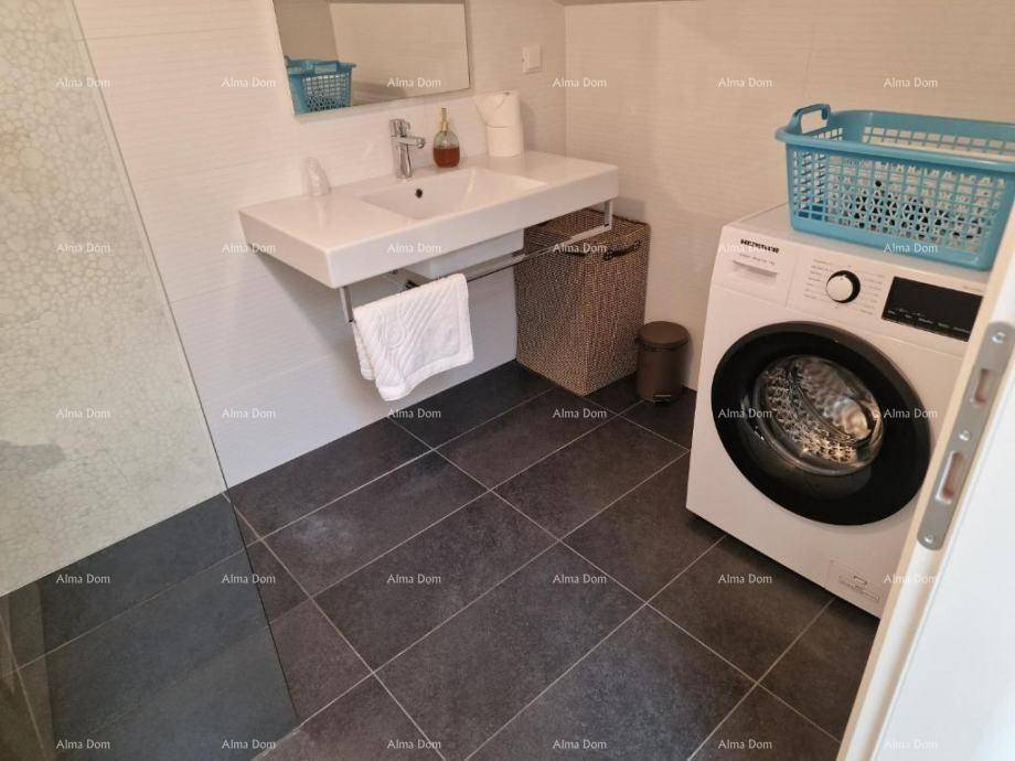 Modernes Badezimmer mit Waschbecken, Duschbereich und dunklen Bodenfliesen.