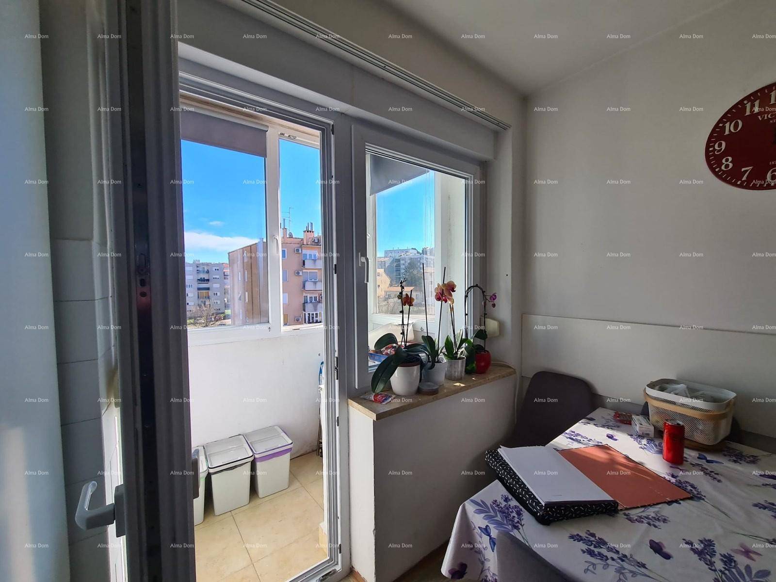 Essbereich in der Küche mit Zugang zu einem verglasten Balkon.