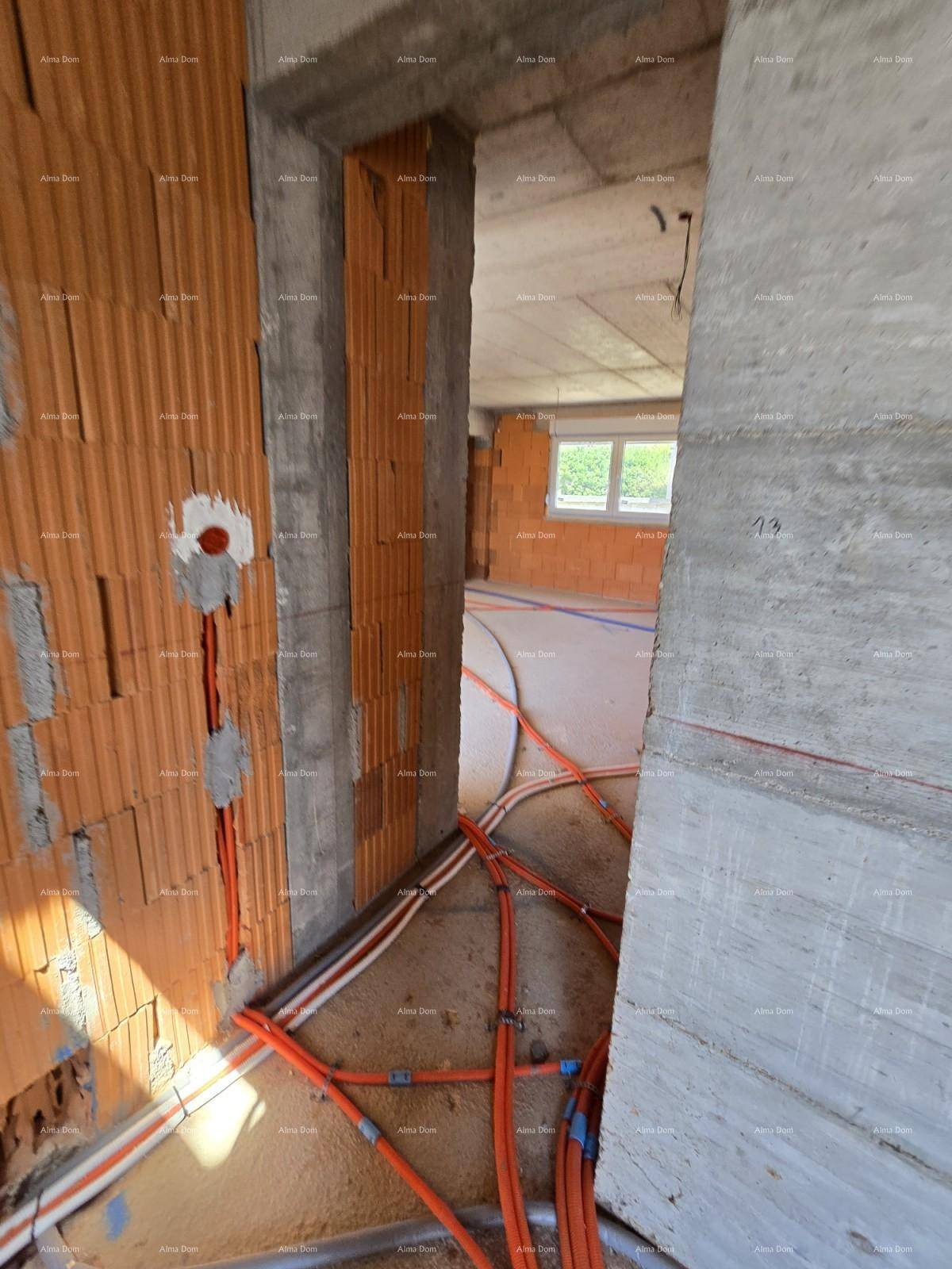 Innenraum im Rohbau mit Ziegelwänden, sichtbaren Leitungen und Betonboden.