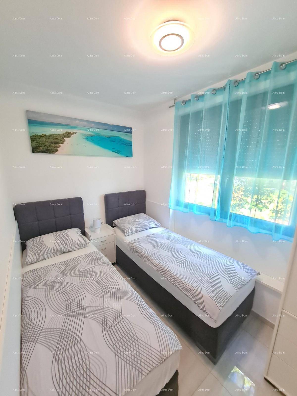Zweites Schlafzimmer mit zwei Einzelbetten und farbigen Vorhängen.