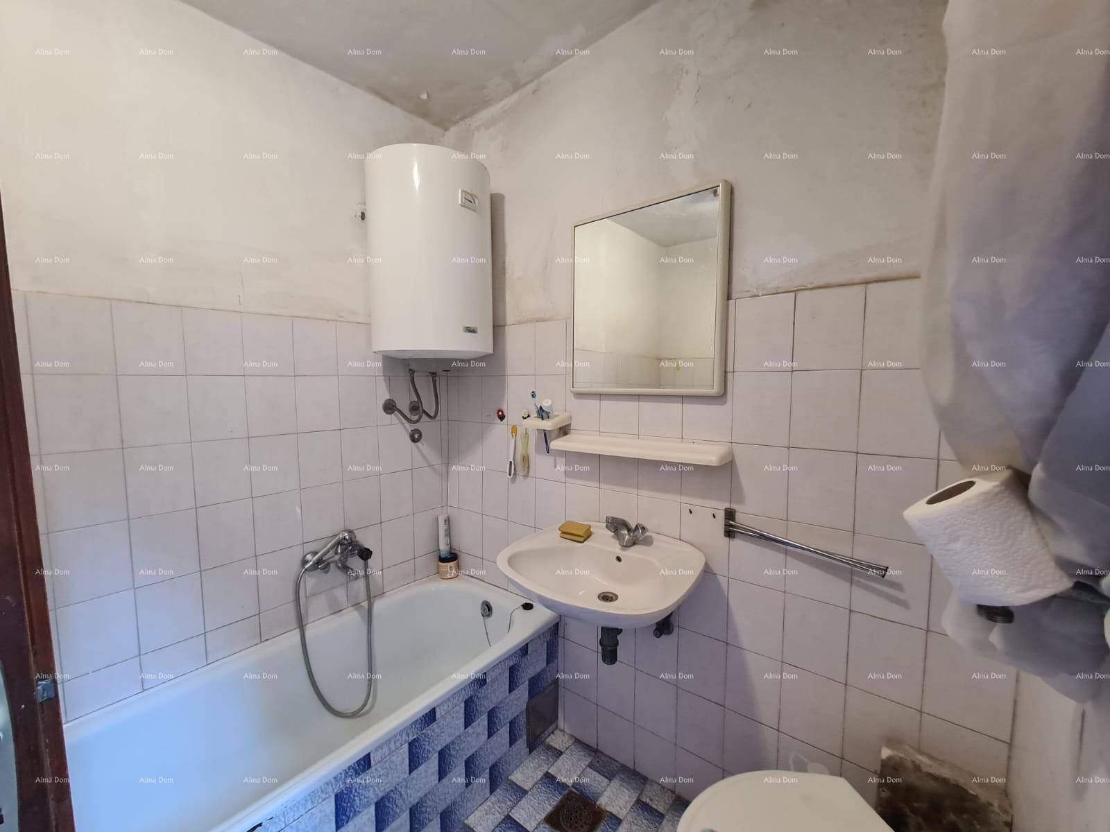 Badezimmer mit weißen Fliesen, Badewanne, Waschbecken und einem Wandspiegel.