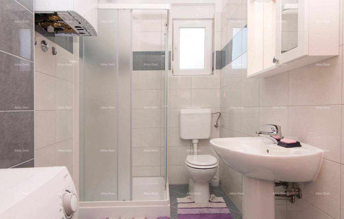 Helles Badezimmer mit Duschkabine, Toilette, Waschbecken und Waschmaschine in Weiß und Grau.