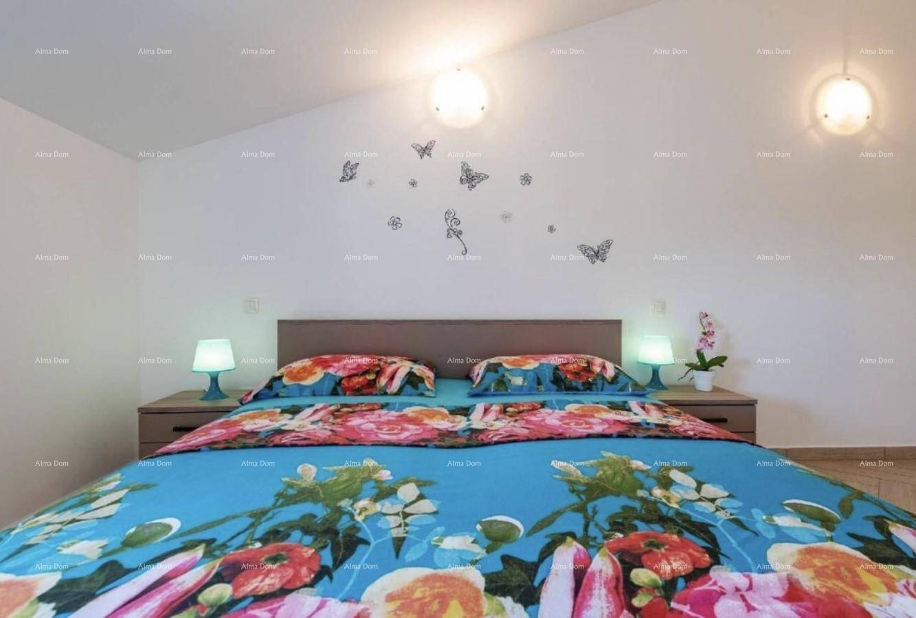 Schlafzimmer mit Doppelbett, floraler Bettwäsche und Nachttischen mit Lampen.