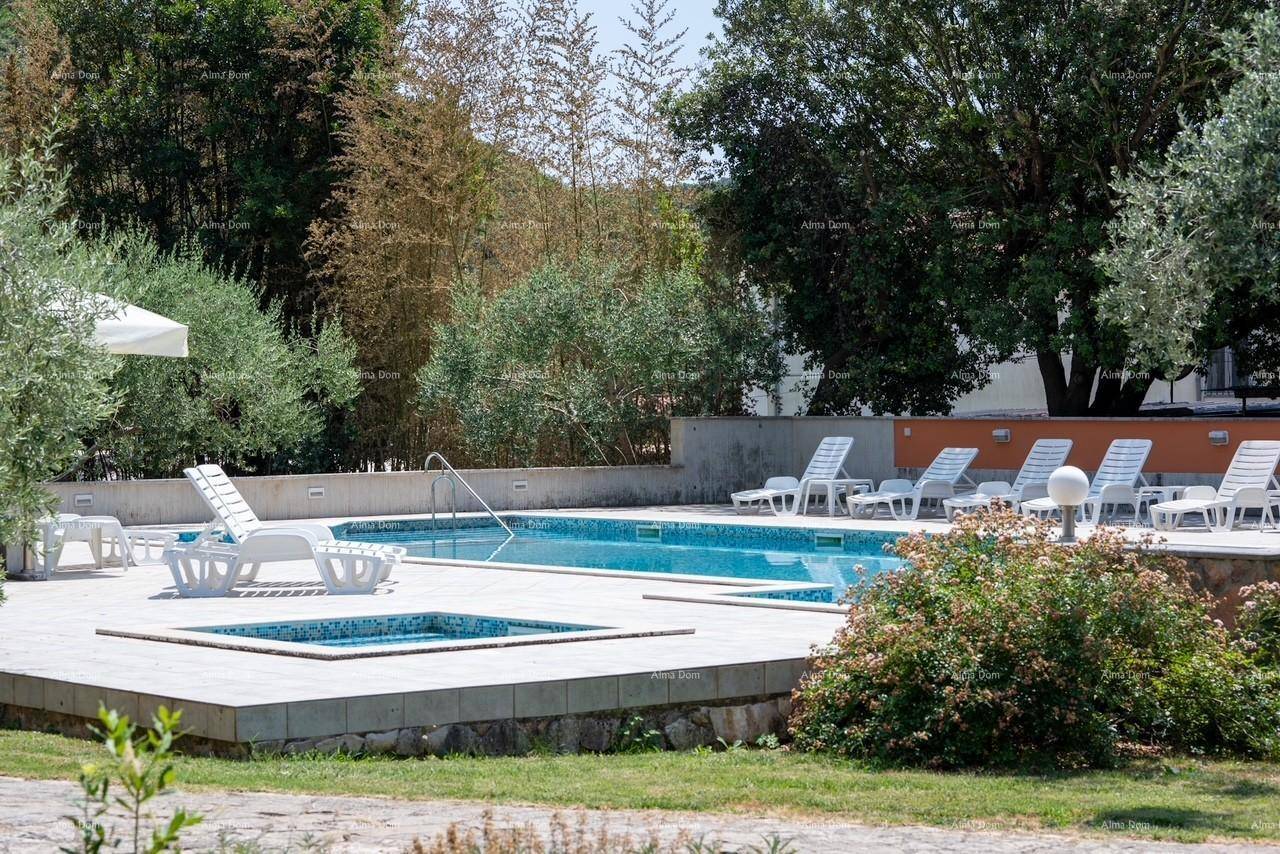 Weitläufiger Poolbereich mit Liegestühlen und einem kleineren Becken, umgeben von mediterraner Bepflanzung.